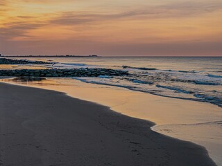 Serene beach sunset with gentle waves.