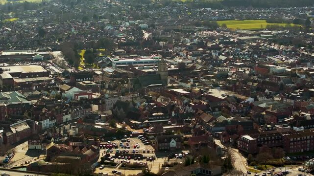 A city view with a large building in the middle. The building is surrounded by cars and trucks