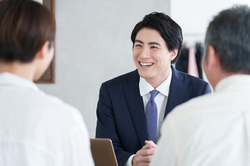 打ち合わせする営業マンと親子の客