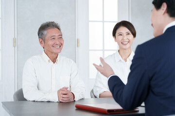 打ち合わせする営業マンと親子の客