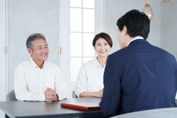 打ち合わせする営業マンと親子の客
