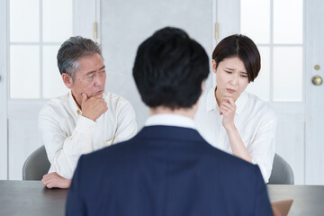 打ち合わせする営業マンと親子の客