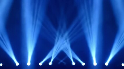 Dynamic blue stage lights illuminate a dark background creating a vibrant abstract pattern.