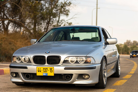 Rishon Lezion, Israel 22.08.2024. BMW M5 E39 parked on the street on a warm summer day against a wall with graffiti in the background.