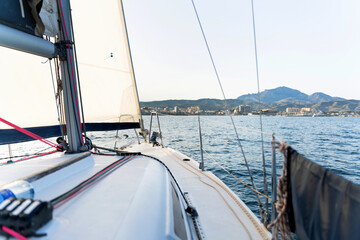 Fototapeta premium Sailboat sailing near the coast on a sunny day