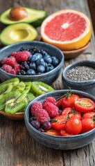 Fresh mixed berries, tomatoes, and superfoods in bowls on rustic wooden table