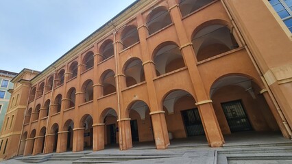 A terracotta-colored historic building in Nice, France, featuring a series of symmetrical arches and a neoclassical architectural style.