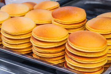 A stack of pancakes in close-up on a dark dish.
