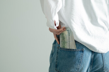 Hands placing hundred dollar bills into pocket