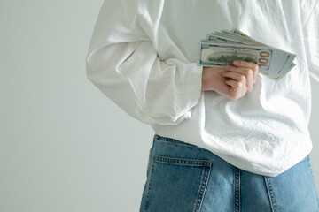 Hidden financial transaction, money behind back. Shadow economy concept, person concealing cash