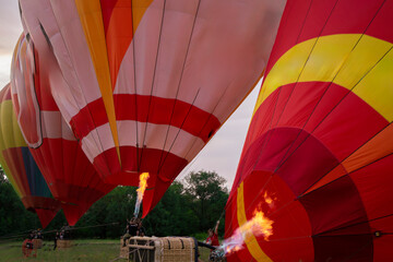 Multiple vibrant aerostat balloons are anchored on the ground
