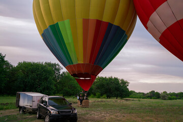 Multiple vibrant aerostat balloons are anchored on the ground
