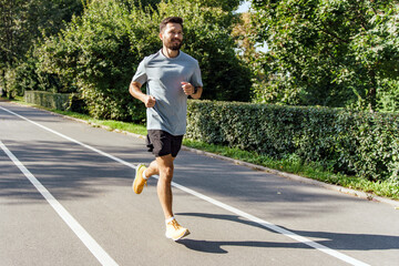 Runner enjoys a peaceful morning jog on a sunny path surrounded by greenery in a city park