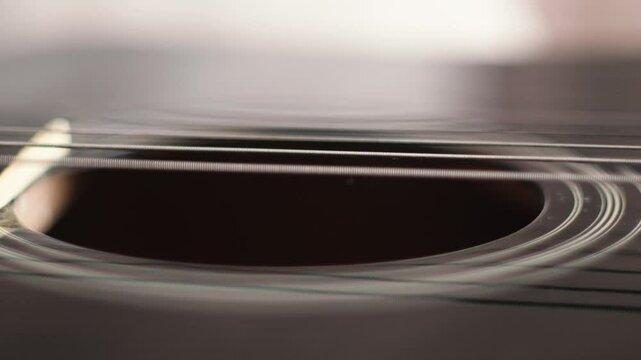 Close-up of buzzing vibrating strings on an untuned guitar, guitar tuning concept, string instrument sound