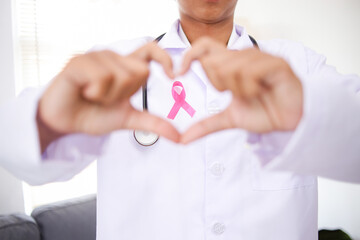 Doctor with Pink Ribbon Making a Heart with Hands for Fight Against Breast Cancer. World Cancer Day.