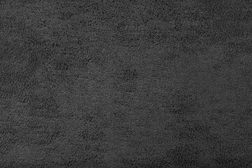 Structure of black suede fabric with abstract shabby texture with embossed shades closeup, macro. Upholstery, decorative cloth structure, canvas for home decor. Background, backdrop, wallpaper.