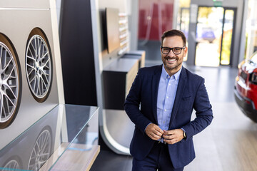Car salesman showing customer rim sizes when buying car