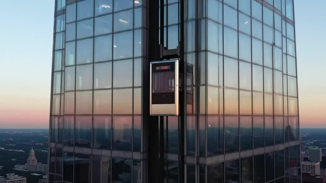 An elevator ascends a tall glass building, showcasing a stunning view of the skyline and vibrant sunset colors reflecting on the windows. The city buzzes below as the evening approaches.
