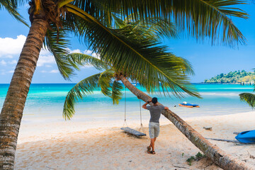 Young man arms outstretched by the sea at sunrise enjoying freedom and life, people travel...