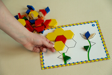 laying out mosaics of different shapes and colors using a stencil