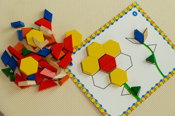 laying out mosaics of different shapes and colors using a stencil