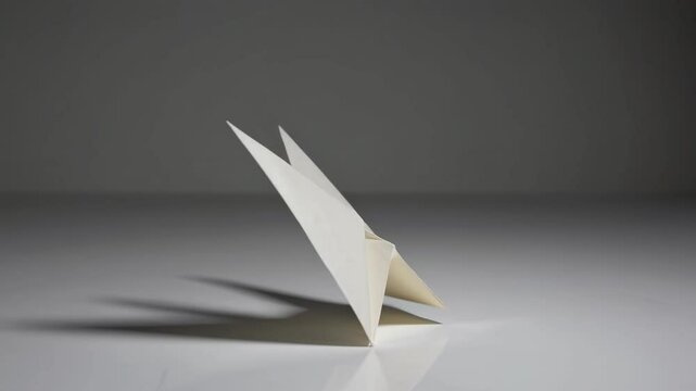 Simple white envelope stands upright on a gray surface, casting a soft shadow. The minimalist design emphasizes elegance and simplicity, perfect for communication or stationery themes