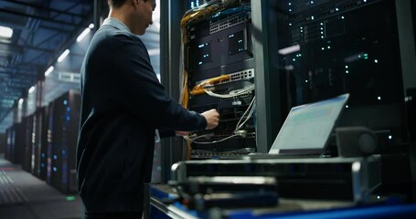 AI Server System Administrator Inserting Additional Hard Drive Storage Units and Bringing Upgraded Cloud Computing Supercomputer Online. Asian Male Specialist Working in a Modern Data Center - Powered by Adobe