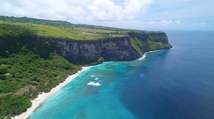 Aerial view of light blue ocean with soft waves crashing into an untouched coastline