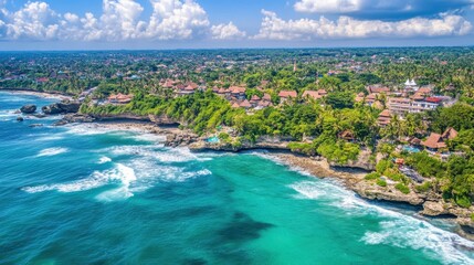 Aerial view of light blue ocean with soft waves crashing into an untouched coastline