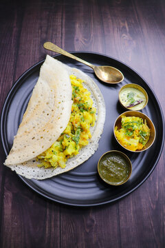 Crispy Masala dosa is a popular South Indian food item served with tomato chutney, coconut chutney, spicy potato masala, or aloo ki sabzi and sambar. Copy space. Crunchy Rice crepes. 