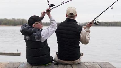 Father and son spend Father's Day fishing. Dad sets an example for his child on how to spend time usefully.