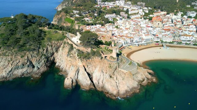 Breathtaking aerial view of tossa de mar, a charming coastal town nestled on the costa brava in catalonia, spain, showcasing its beautiful beach, historic castle, and whitewashed buildings