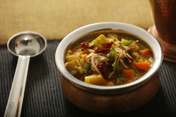 Sambaru curry, South Indian recipe, with a metal pot