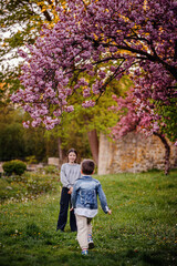 Fototapeta premium Children Playing Together Under Blooming Cherry Tree
