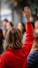 Woman raising hand in crowd, asking question, public forum, possibly meeting or protest