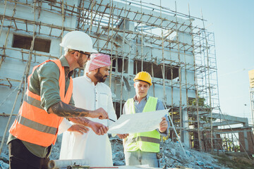 Arab construction engineer architect, Muslim builder working outdoor at construction site with...