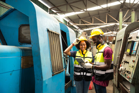 African black man professional technician engineer people workers in heavy industry training control operate CNC machine to young women