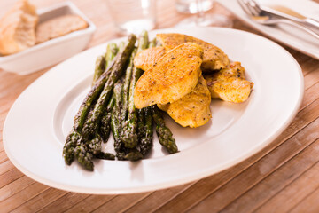 Cooked dish. Chicken nuggets with green asparagus on plate