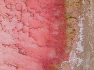 Aerial view of a pink salt lake with textured patterns.