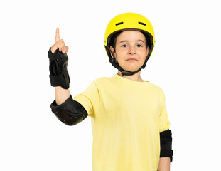 Little boy with bike yellow helmet and pointing away side with finger against a white background