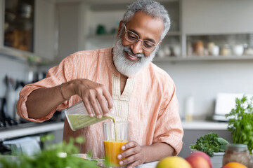 elderly Indian man preparing a healthy breakfast smoothie in a bright modern kitchen, wearing glasses and a kurta