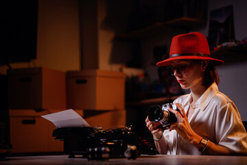 Woman in Red Hat Examining Vintage Camera at Desk