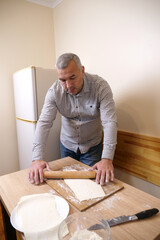A man makes pastries from dough in the kitchen.