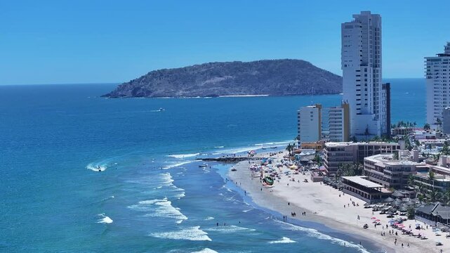Aerial Mexico Mazatlan city sandy beach. Commercial ocean vacation tourism seaport, cargo and cruise ships. Luxury resort Mexican Riviera. Romantic destination. Sand, surf and beach recreation travel.