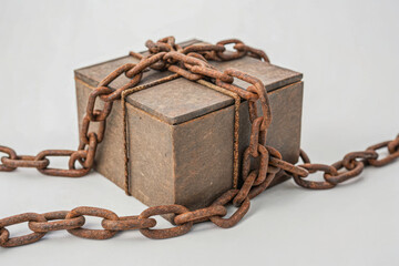 Tariff and barrier concept shown with rusty chain wrapped around metal box