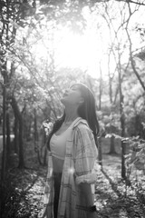 Southeast asian female young woman enjoying refreshing deep breath in sunlit public park expressing wellness and embracing healthy lifestyle in nature