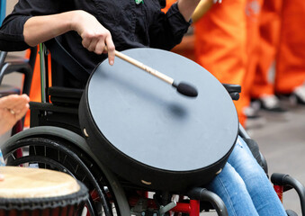 Musician playing drums while sitting in wheelchair during parade
