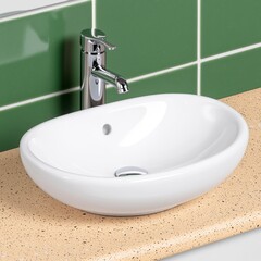 Fototapeta premium Modern Oval White Ceramic Sink with Chrome Faucet and Green Tile Backsplash