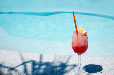 A delicious berry cocktail in an elegant glass on the side of the pool