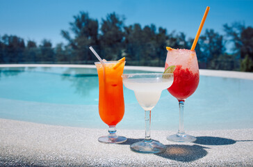 Delicious berry cocktails in elegant glasses on the side of the pool
